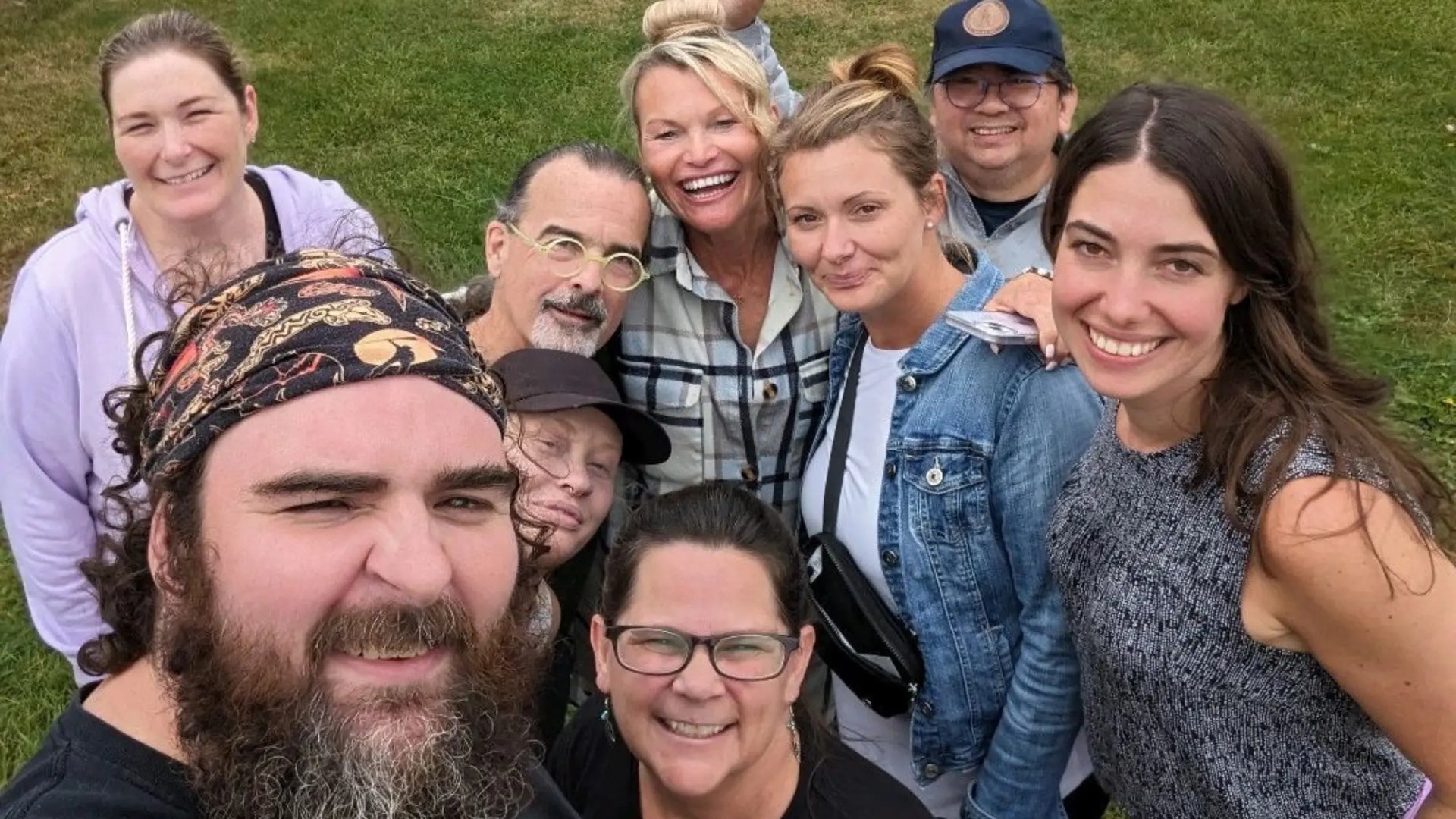 Group smiling together outdoors after a team building retreat